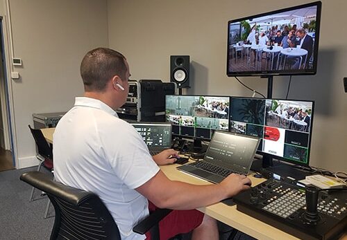 L'homme au bureau contrôle le flux vidéo en studio.
