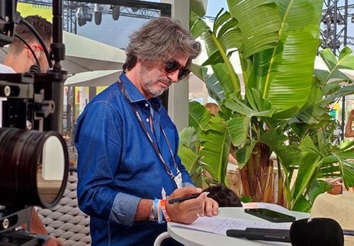 Un homme en chemise bleue écrit à Cannes LIONS 2022.