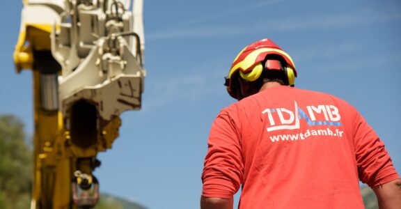 Personne en rouge près de la machinerie lourde.