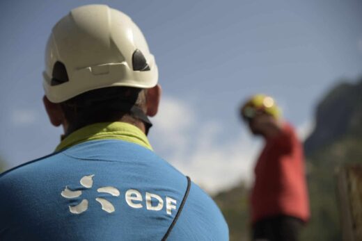 Personne en bleu EDF, dos tourné, une autre en rouge.