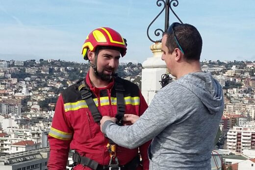 Un pompier sur un toit avec assistance.